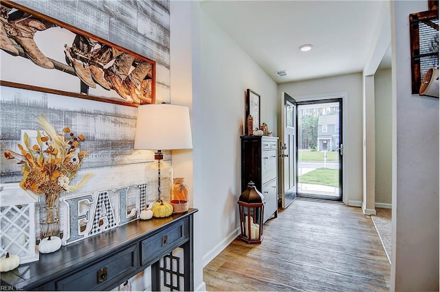 entryway with baseboards, visible vents, and light wood finished floors