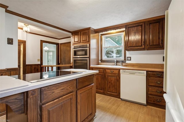 kitchen with sink, light hardwood / wood-style flooring, white appliances, and ornamental molding