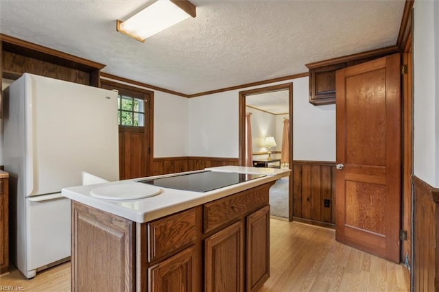 kitchen featuring a center island, black electric stovetop, light wood-type flooring, and white refrigerator