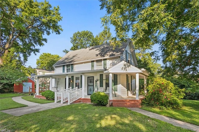 farmhouse-style home with a front lawn and covered porch