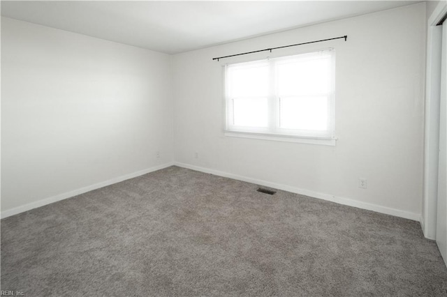 carpeted empty room with visible vents and baseboards