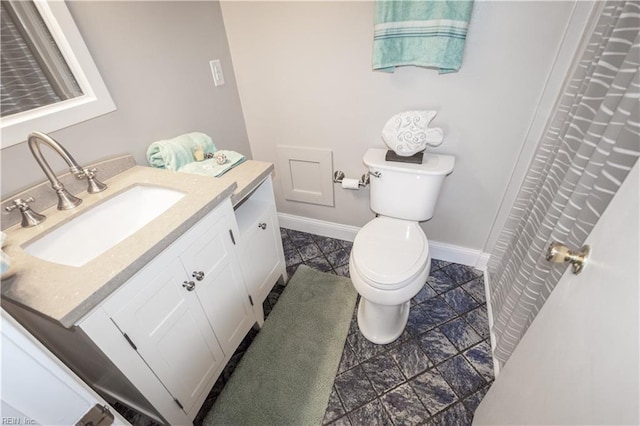 full bathroom featuring vanity, toilet, and baseboards