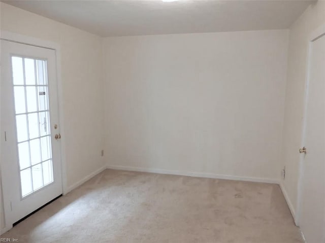 empty room featuring baseboards, light colored carpet, and a healthy amount of sunlight