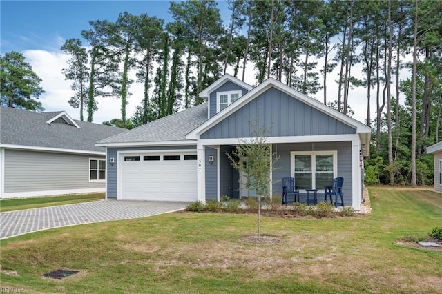 view of front of house with a porch, a garage, and a front lawn