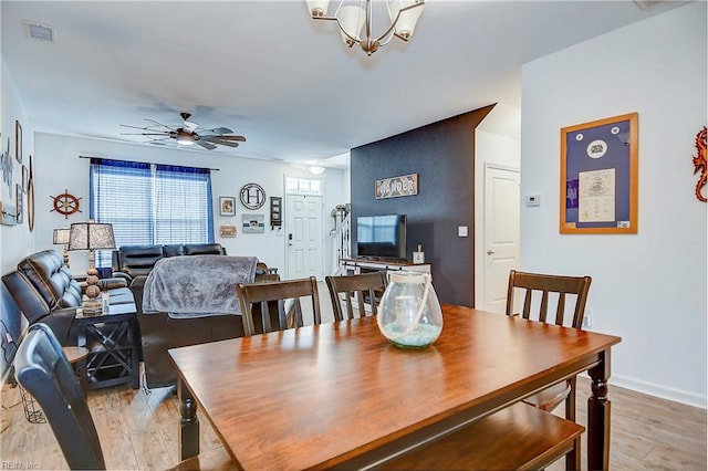 dining area featuring light wood-type flooring, visible vents, ceiling fan, and baseboards