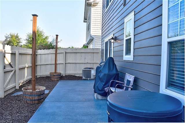 view of patio with a fenced backyard and central air condition unit