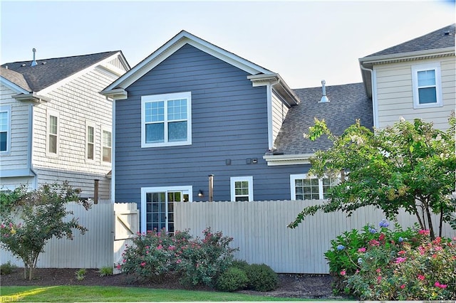 exterior space with a shingled roof and fence