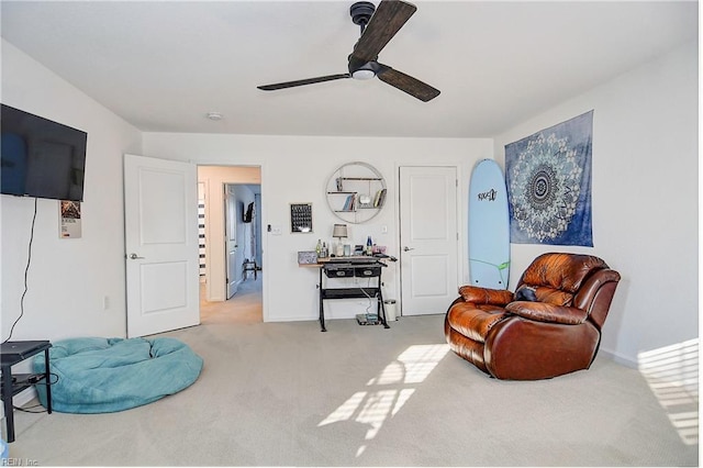 sitting room featuring carpet floors, a ceiling fan, and baseboards