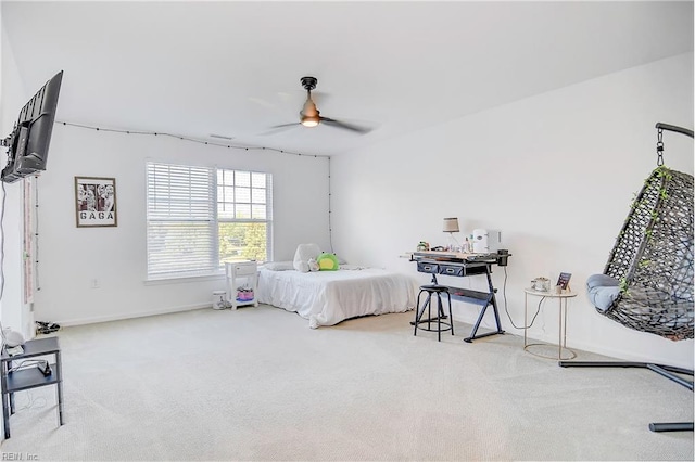 carpeted bedroom with ceiling fan and baseboards