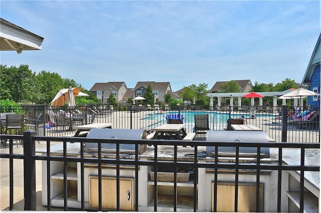 exterior space featuring a community pool, fence, a patio, and a residential view