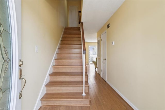 staircase with baseboards and wood finished floors