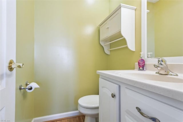 bathroom with vanity, toilet, and baseboards