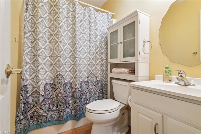 bathroom featuring a shower with curtain, toilet, and vanity