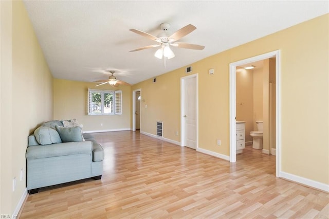 sitting room with a ceiling fan, visible vents, baseboards, and light wood-type flooring