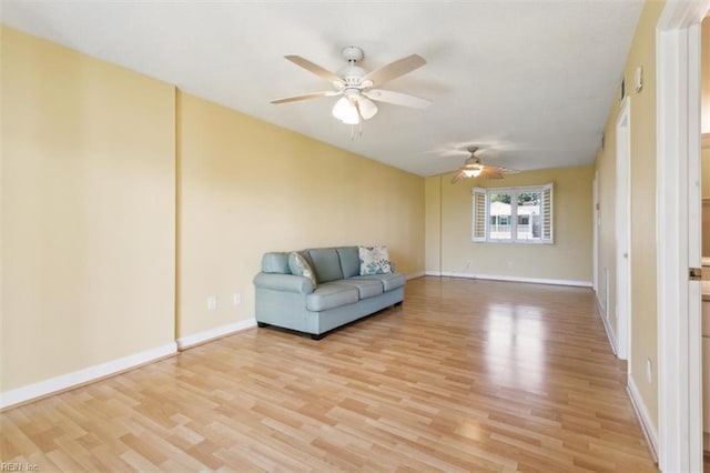 unfurnished living room featuring light wood-style flooring, baseboards, and ceiling fan