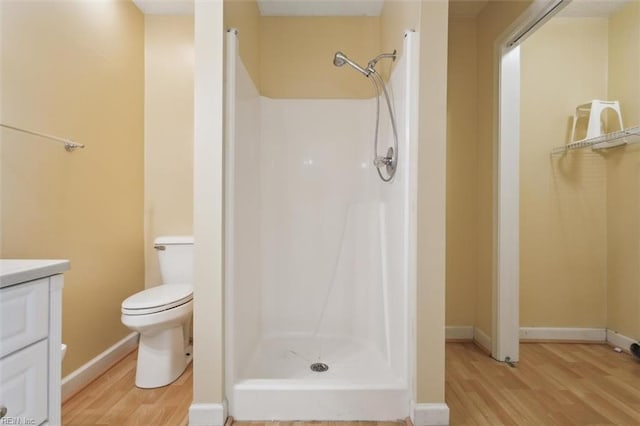 full bathroom featuring a stall shower, vanity, and wood finished floors