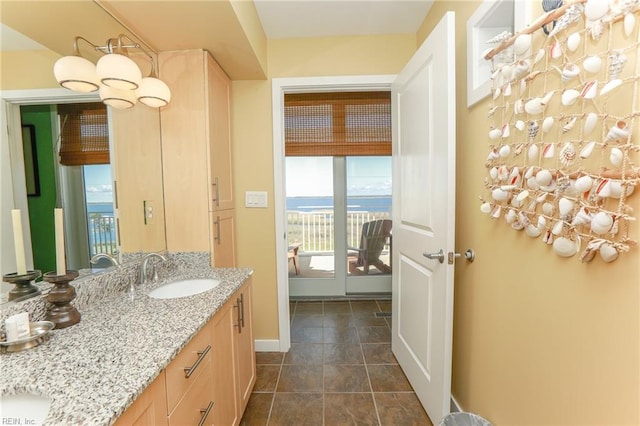 bathroom with a water view, tile patterned flooring, and vanity