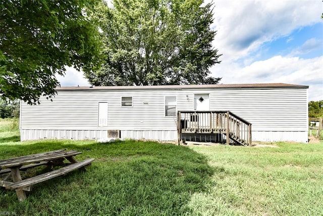 back of property featuring a deck and a lawn