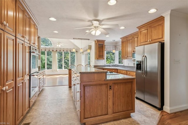 kitchen with stainless steel fridge, a healthy amount of sunlight, decorative light fixtures, and ceiling fan