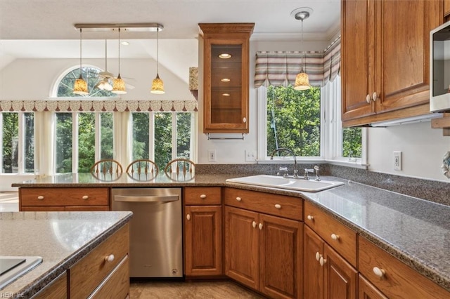 kitchen featuring glass insert cabinets, pendant lighting, brown cabinets, appliances with stainless steel finishes, and a sink