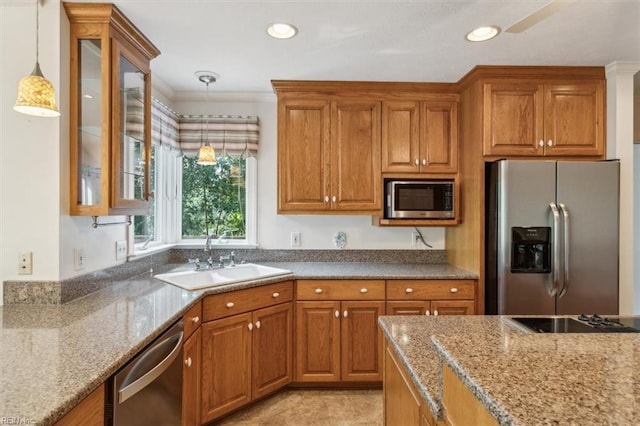 kitchen featuring a sink, decorative light fixtures, brown cabinetry, and stainless steel appliances