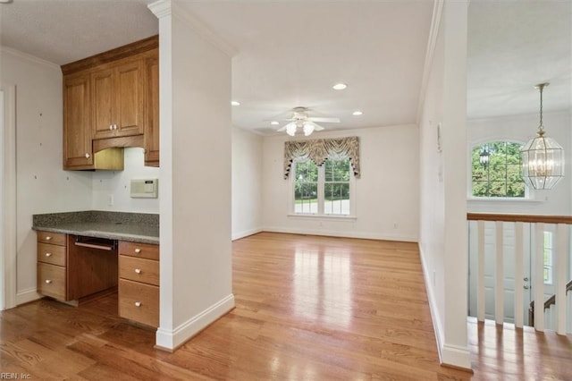 kitchen featuring ceiling fan with notable chandelier, crown molding, built in desk, and light hardwood / wood-style floors