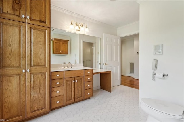 bathroom with toilet, crown molding, and vanity