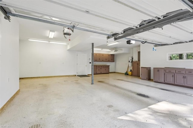 garage with a garage door opener and baseboards