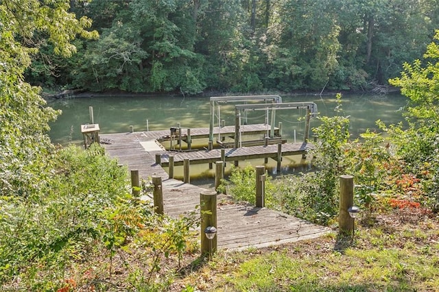 dock area featuring a wooded view and a water view