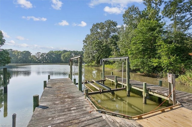 dock area with boat lift and a water view