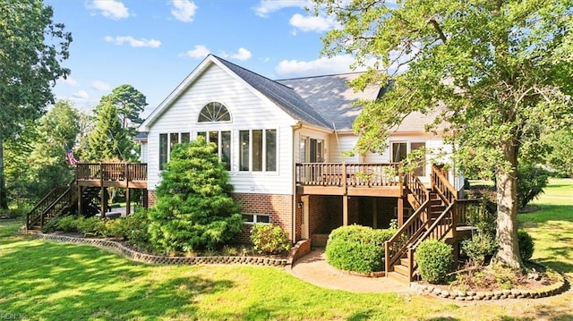 rear view of property with a lawn and a wooden deck