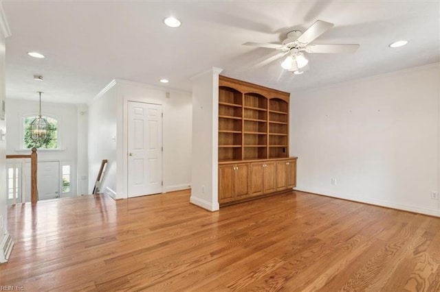 interior space featuring light hardwood / wood-style flooring, ornamental molding, and ceiling fan with notable chandelier