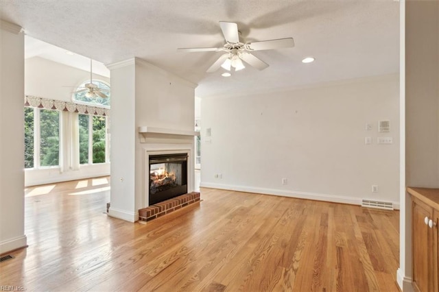 unfurnished living room featuring a brick fireplace, light hardwood / wood-style flooring, and ceiling fan