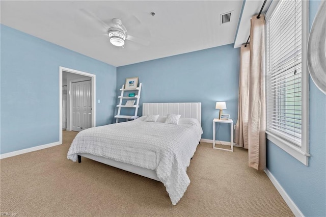 carpeted bedroom featuring a ceiling fan, visible vents, and baseboards