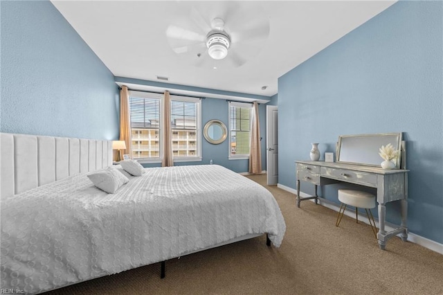 carpeted bedroom with ceiling fan and baseboards