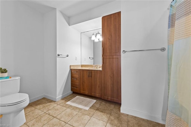 bathroom featuring tile patterned flooring, baseboards, vanity, and toilet