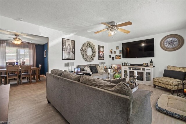 living room featuring a textured ceiling, hardwood / wood-style floors, and ceiling fan