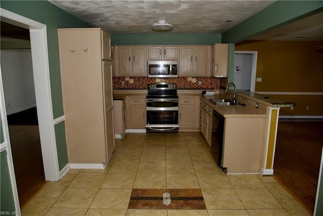 6703 Chambers Ln, Suffolk, VA 23435 - kitchen featuring appliances with stainless steel finishes, a sink, a peninsula, baseboards, and tasteful backsplash