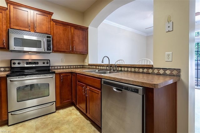 kitchen featuring stainless steel appliances, a peninsula, a sink, dark countertops, and crown molding