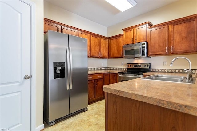 kitchen featuring stainless steel appliances, brown cabinetry, and a sink