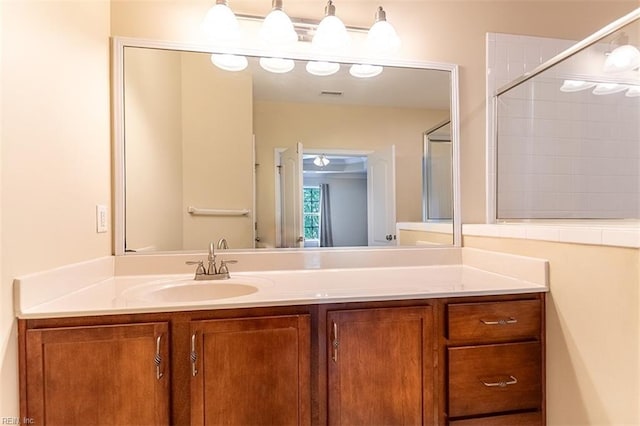 bathroom featuring visible vents, vanity, and walk in shower