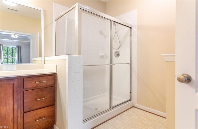 full bath featuring visible vents, a stall shower, vanity, baseboards, and tile patterned floors