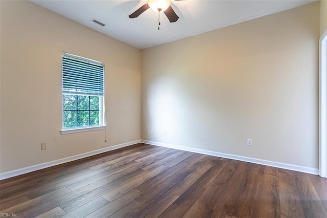 spare room featuring a ceiling fan, baseboards, visible vents, and dark wood-type flooring