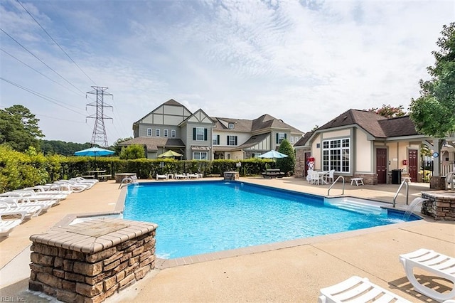 pool with a patio area and fence