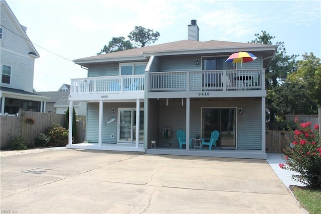 rear view of property with a balcony and a patio area