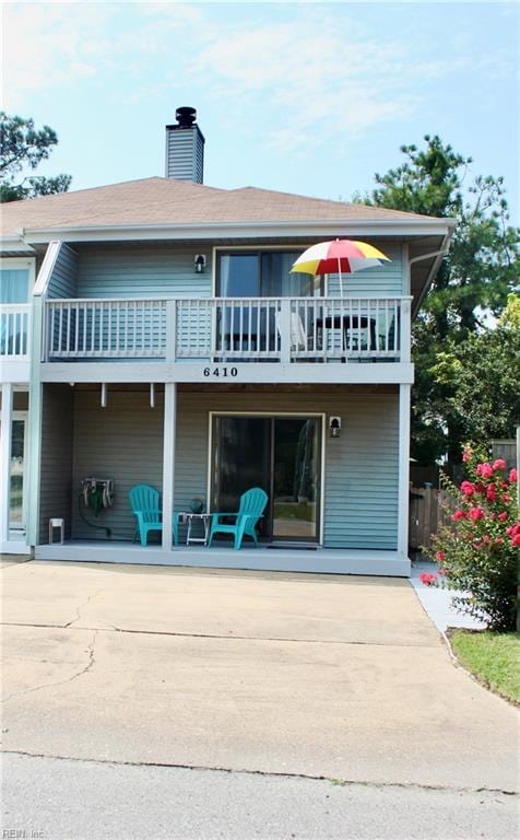 rear view of house featuring a patio area and a balcony