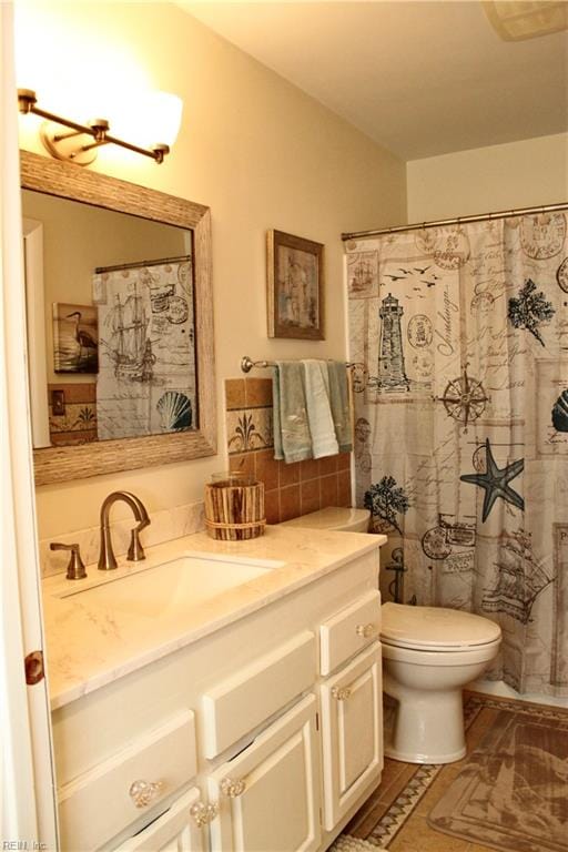 bathroom with vanity, toilet, and tile walls