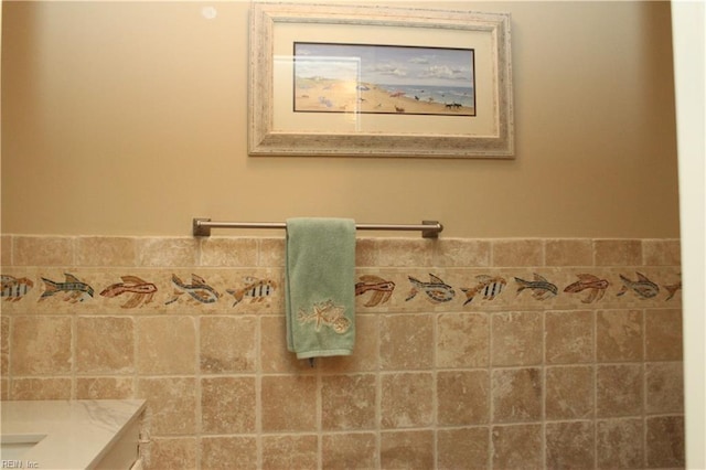 bathroom with vanity and tile walls