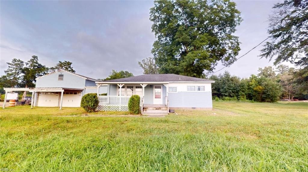 view of front of home featuring a front lawn, covered porch, and a garage