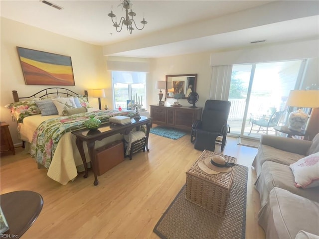 bedroom featuring light hardwood / wood-style floors, a notable chandelier, and access to outside